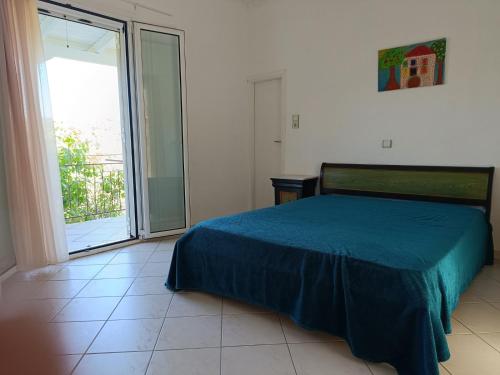 a bedroom with a bed and a large sliding glass door at Konstantina's House I in Koroni