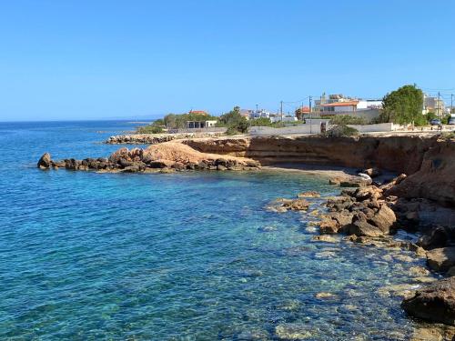 a view of the ocean from a rocky beach at Artemis Boutique House in Artemida