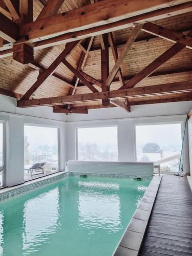 - une piscine dans une chambre dotée d'un plafond en bois dans l'établissement Villa piscine intérieure, sauna, 5 chambres, à Marennes