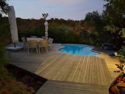 a patio with a table and a swimming pool at Milkwood Safari Lodge in Warmbaths