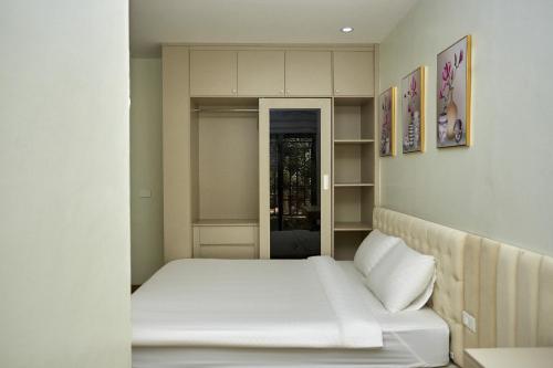 a small bedroom with a bed with white sheets at An's House SaPa - Nguyên Căn 5 Phòng Ngủ View Núi in Sa Pa