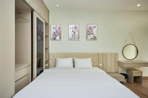 a bedroom with a white bed and three paintings on the wall at An's House SaPa - Nguyên Căn 5 Phòng Ngủ View Núi in Sa Pa