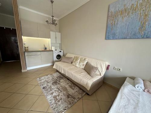 a living room with a couch and a kitchen at Студио Виви с двор in Néa Péramos