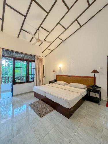a bedroom with a large bed and a large window at Moonbeam Kandy in Kandy