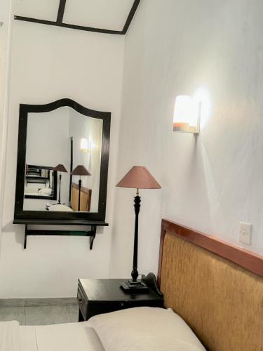 a bedroom with a bed and a mirror on the wall at Moonbeam Kandy in Kandy