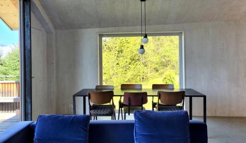 a dining room with a blue couch and a table at Chalet contemporain in Gryon