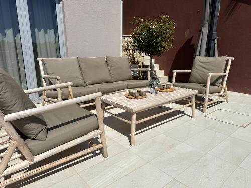 zwei Stühle und ein Sofa und ein Couchtisch auf einer Terrasse in der Unterkunft SeaZen Luxury Seaside Apartment Korcula in Račišće