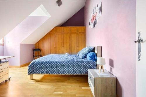 Un dormitorio con una cama azul y paredes moradas en Chez Maria chambre chez l'habitant, en Milly-la-Forêt