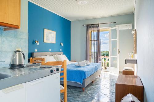 Anastasia Studios Katelios في كاتيليوس: غرفة نوم زرقاء مع سرير ومطبخ