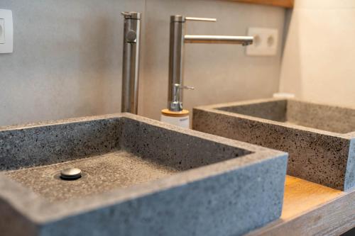 a bathroom with a concrete sink with a faucet at Vakantiehuis Braembeyerhoek in Bruges