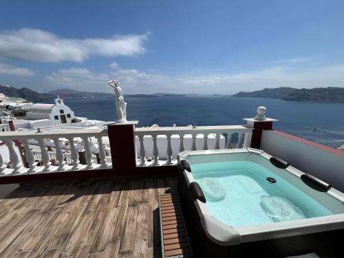 uma banheira de hidromassagem numa varanda com vista para o oceano em Maryloujohn Villas Oia em Oia