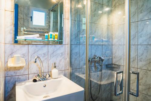 W łazience znajduje się umywalka i prysznic. w obiekcie Anastasia Studios Katelios w mieście Kateleios