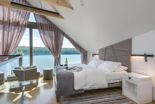 a bedroom with a large bed and a large window at PRZYSTAŃ WYGONIN knéżka i wino in Wygonin