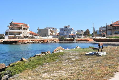 a bench sitting on the side of a river at Artemis Boutique House in Artemida