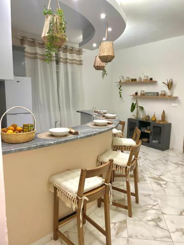 a kitchen with a counter with chairs and a table at Casa Lulu cabo verde in Praia