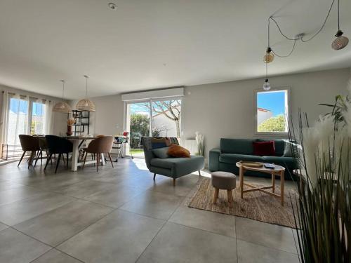 un salon avec un canapé vert et une table dans l'établissement La Maison Mer Villa familiale pour 8 proche de la plage, à Jard-sur-Mer