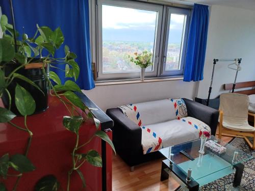 een woonkamer met een bank en een raam bij 30 qm komfort wohnung in Keulen