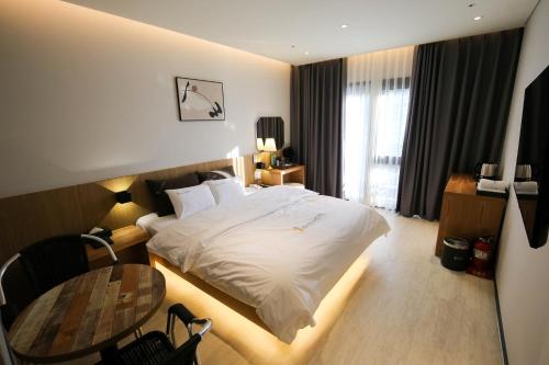 a hotel room with a bed and a table at Chungjangro Ilbeonji Boutique Hotel in Gwangju