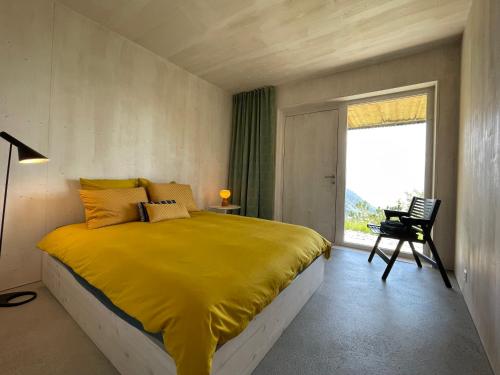 a bedroom with a yellow bed and a window at Chalet contemporain in Gryon