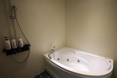 a bath tub in a bathroom with a shower at Chungjangro Ilbeonji Boutique Hotel in Gwangju