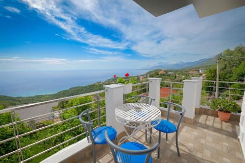 a balcony with a table and chairs and a view of the ocean at Eduard Lagji Apartament in Lukovë
