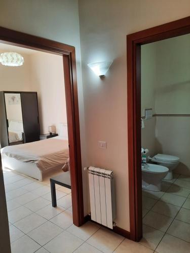 a bedroom with a bed and a bathroom with a toilet at Casa Messina Inn in Messina