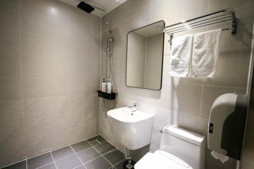 a bathroom with a toilet and a sink and a mirror at Chungjangro Ilbeonji Boutique Hotel in Gwangju