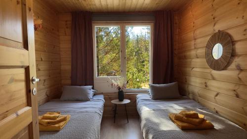 dwa łóżka w pokoju z oknem w obiekcie Villa Kolovesi - Saimaa Retreat w mieście Savonlinna