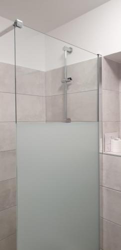La salle de bains est pourvue d'une douche en verre avec un robinet. dans l'établissement Studio meublé 3 étoiles, au Lavandou