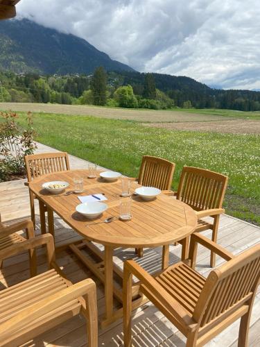 ヘルマゴルにあるEntspannen im Holzchalet mit Panoramablick, Ruhe und Infrarotsaunaの木製デッキ(木製テーブル、椅子付)
