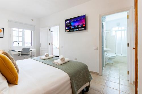 um quarto com uma cama e uma televisão na parede em Casa El Drago 6 em Breña Baja