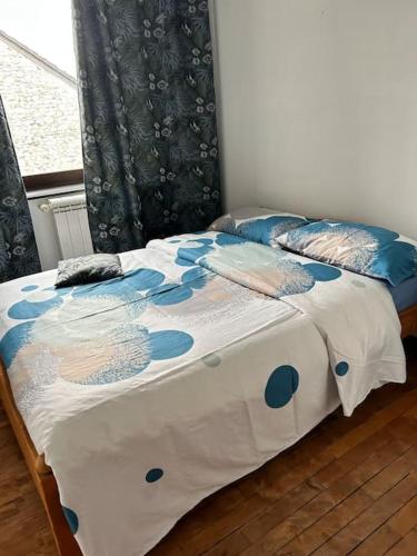 a bed with a blue and white comforter and pillows at Maison avec jardin, 3 chambres in Clavier