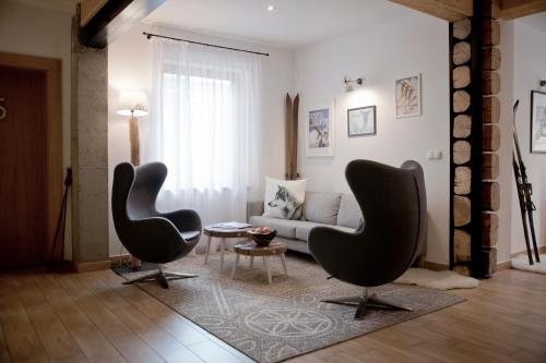 a living room with two chairs and a couch at Villa 11 Folk & Design in Zakopane