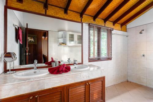 La salle de bains est pourvue d'un lavabo et d'un miroir. dans l'établissement Beachfront Villa, Bang Po, à Ban Bang Po