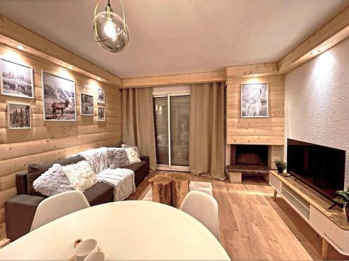 ein Wohnzimmer mit einem Sofa und einem Kamin in der Unterkunft LeChalet N22 Au pied des pistes in Saint-Lary-Soulan