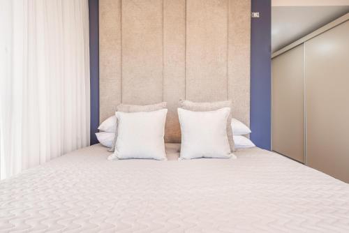 a bedroom with a bed with white pillows at Luxury 3BDR In The Heart Of Jerusalem in Jerusalem