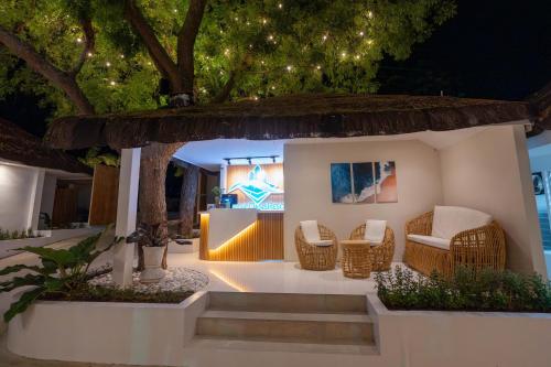 a home with chairs and a table and a tree at Serene Oasis Resort - Oslob Cebu Philippines in Oslob