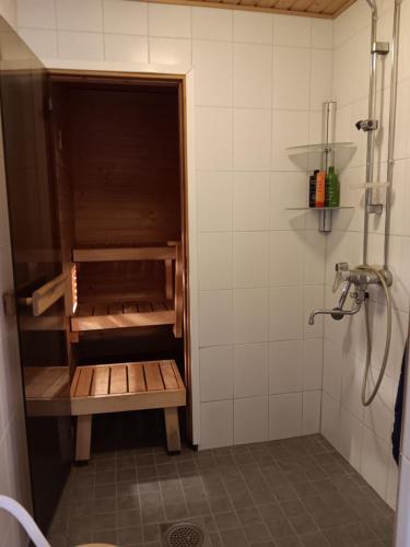 uma pequena casa de banho com um chuveiro e uma prateleira de madeira em Old Bank em Hämeenkoski