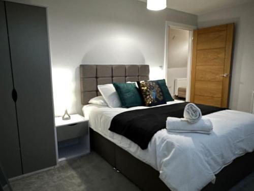 een slaapkamer met een groot bed met een houten hoofdeinde bij Modern, spacious with s/king bed Apartment in Brentwood