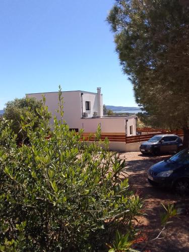 a building with cars parked in a parking lot at Gite de l'Etang proche des Grands Buffets in Narbonne
