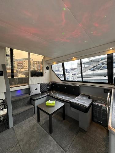 a living room with a couch and a table at YACHT "X" - 44 FOOT MODERN YACHT ON 5 STAR OCEAN VILLAGE MARINA - minutes away from city centre and cruise terminals, Free parking ,SPA package available! in Southampton