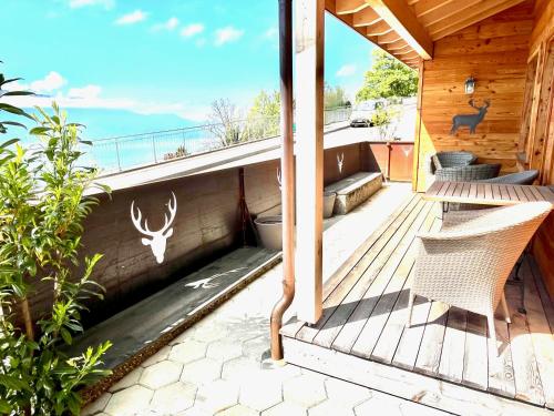 a deck with two chairs and a view of the ocean at Le Petit Observatoire in Chardonne