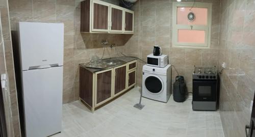 een keuken met een koelkast, een wasmachine en een droger bij ماجيك سويت الرقعى Magic Suite AlRaggi in Koeweit