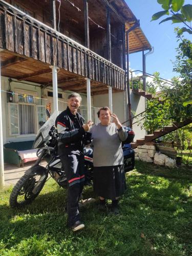 two women standing in the grass next to a motorcycle at Chogovadze's Guest House in K'vemo Zhoshkha