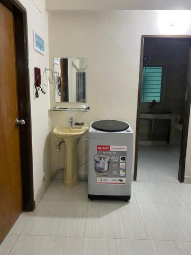 ein Badezimmer mit einem Waschbecken und einer Waschmaschine in der Unterkunft Service Apartment in Dhaka