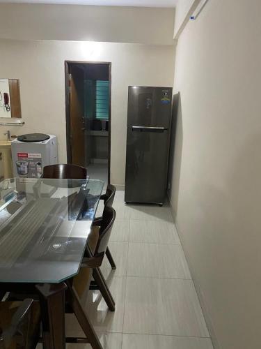 ein Esszimmer mit einem Tisch und einem Kühlschrank in der Unterkunft Service Apartment in Dhaka