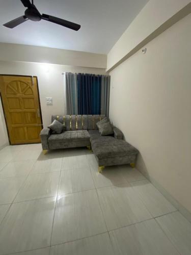 ein Wohnzimmer mit Sofa und Tür in der Unterkunft Service Apartment in Dhaka