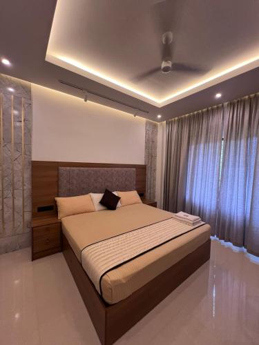 a bedroom with a bed and a large window at Royale Revera in Cochin