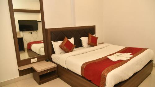 a bedroom with a large bed and a mirror at Hotel MM Continental in Varanasi
