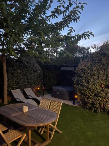 a table and chairs and a grill in a yard at Mazet des Orchidées - Gîte 4 personnes 50 m2 - Jardin, spa privé - indépendant - stationnement privé in Servian